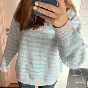 Randig stickad tröja från Gina Tricot - Säljer en randig stickad tröja från Gina Tricot i ljusblått och grått. Tröjan har långa ärmar och en bekväm passform. Den är tillverkad i ett mjukt material💙Tröjan är stor i storleken så passar även för 170!