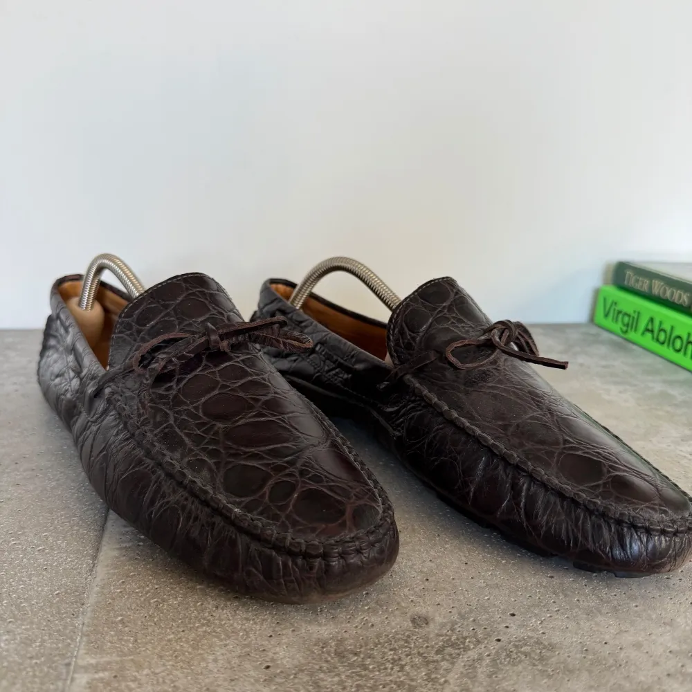 Snygga bruna loafers i skinn från Dueri med krokodilmönster. Skorna har en klassisk design med snörning och är tillverkade i Italien. Perfekta för en stilren look.. Kengät.