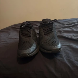 Nike svart 270 - Snygga svarta Nike sneakers med en modern design och bekväm passform. Skorna har en luftig ovandel och en synlig Air-enhet i hälen för extra dämpning. Perfekta för både träning och vardagsbruk. Knappt använda säljer för har tappat intresset för dem och skaffat andra svarta skor