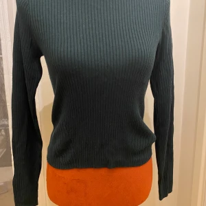 Mörkgrön ribbad tröja från H&M Divided M - Säljer en stilren mörkgrön ribbad tröja från H&M Divided. Tröjan har en klassisk rund hals och långa ärmar, perfekt för en avslappnad look. Passar bra till både jeans och kjol. Färg: petrol  Längd: 55 cm Ärmhåla till ärmhåla: 42 cm  Inga bilder när den sitter på mig!