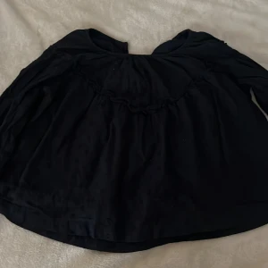 Svart blus från Gina Tricot - Säljer en svart blus från Gina Tricot med fina detaljer. Blusen har en lös passform och är tillverkad i ett lätt material. Perfekt för olika tillfällen och enkel att matcha med andra plagg.