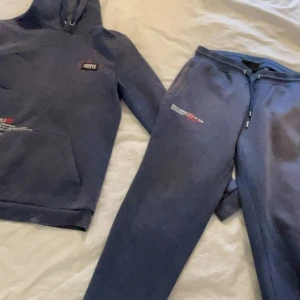 Mörkblå mjukisbyxor från Supply & Demand - Säljer ett par mörkblå mjukisbyxor från Supply & Demand. Byxorna har en bekväm passform med snörning i midjan och en liten logga på benet. Perfekta för en avslappnad stil.