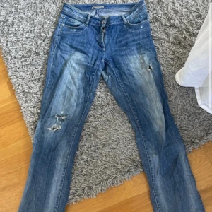 Blå jeans med slitningar - Säljer ett par blå jeans med coola slitningar. Köpta second hand från märket Cecil. Storlek 36! 