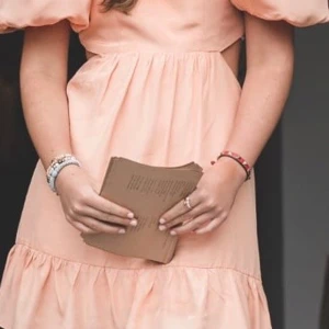 Persikofärgad klänning från By Malina - Charmig persikofärgad klänning från By Malina med puffiga kortärmar och volangdetaljer. Klänningen har en öppen rygg med knytning och en v-ringad framsida. Perfekt för en somrig look!