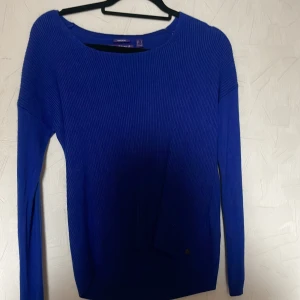 Blå ribbad tröja från Mexx - Snygg blå ribbad tröja från Mexx med långärmad design. Perfekt för kyligare dagar och kan enkelt matchas med olika outfits. Tröjan har en klassisk passform och är tillverkad i ett mjukt material för extra komfort.