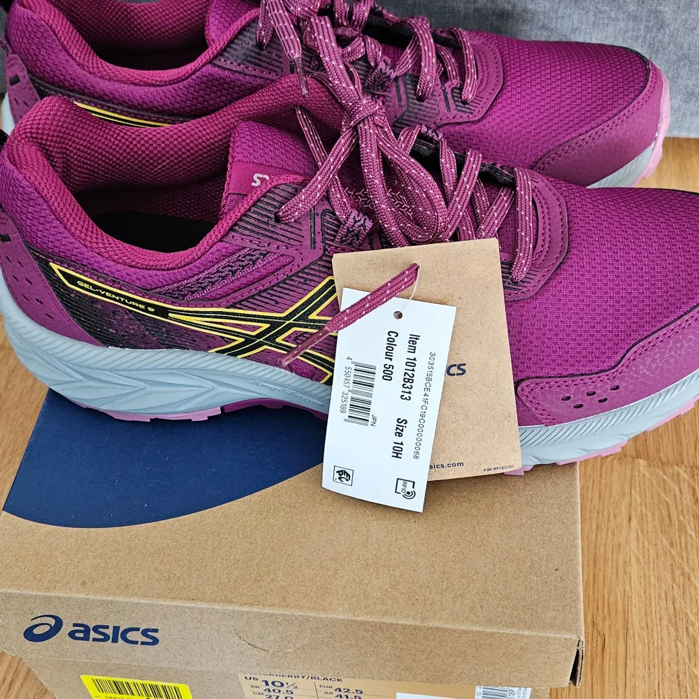 Snygga lila löparskor från Asics med svart och gul detaljering. Skorna har en robust sula med bra grepp och snörning för optimal passform. Perfekta för löpning och träning. . Kengät.