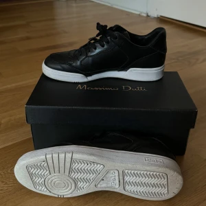 Svarta sneakers från Polo Ralph Lauren 38 - Snygga svarta sneakers från Polo Ralph Lauren med vit sula och diskret logotyp på sidan. Skorna har snörning och är tillverkade i skinn, vilket ger en stilren look. Perfekta för en avslappnad stil. 