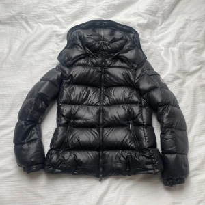 Svart dunjacka från Moncler - Moncler dunjacka till dam🤩 Storlek 2 Äkta, går att verifiera med kod på monclers hemsida Använd men i mycket fint skick, har endast en defekt på insidan av höger ficka vilket inte syns eller märks så länge den inte öppnas                   Hör av dig vid eventuella frågor!☺️