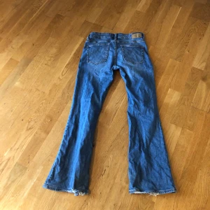 Blå jeans från 157 - Snygga blå jeans från 157 i storlek S. De har en klassisk femficksdesign med dragkedja och knapp framtill. Jeansen har en bootcut-stil och är perfekta för en avslappnad look.