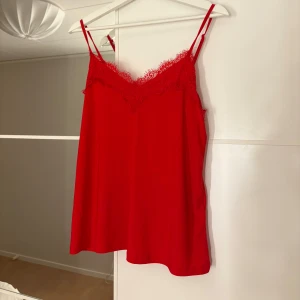 Röd linne med spetsdetaljer - Snygg rött linne med spets. Hör av er vid funderingar eller om ni vill ha bilder med hur plagget sitter på mig. Titta gärna in mina andra plagg!