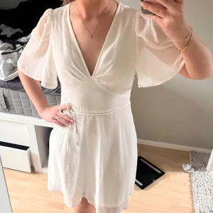 Studentklänning - Jätte fin vit kortklänning! Endast använd en gång så i riktigt bra skick💕avtagbart band och liten dragkedja på sidan💗