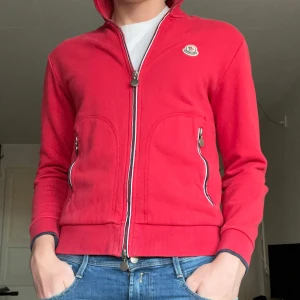 Moncler Cardigan  - Säljer nu en sällsynt röd moncler cardigan. Storleken är M/L och skicket är bra. Hör av er vid eventuella frågor! Priset är ej hugget i sten! 