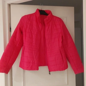 Rosa quiltad jacka - Säljer en snygg rosa quiltad jacka med dragkedja. Jackan har en normal passform och långa ärmar, perfekt för vår och höst. Den är både stilren och praktisk med en enkel design.
