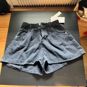 Svarta shorts från Bershka - Snygga svarta shorts från Bershka med hög midja. Perfekta för sommardagar. Shortsen har praktiska fickor och är tillverkade i ett bekvämt material. Har aldrig används 