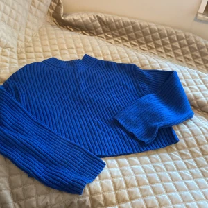 Blå ribbad tröja från H&M - Säljer en snygg blå ribbad tröja från H&M. Tröjan har en croppad design och långa ärmar, perfekt för en stilren look. Passar utmärkt till både jeans och kjol. Perfekt för höst och vår!