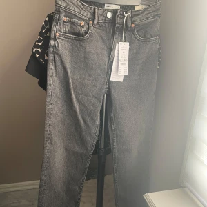 Mid straight jeans Washed grey - Snygga grå jeans från Gina tricot med klassisk femficksdesign och knappgylf. Perfekta för en stilren look. De har en rak passform och är tillverkade i ett slitstarkt denimtyg.