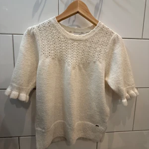 Vit stickad tröja från Holly & Whyte💕 - Säljer en söt vit stickad tröja från Holly & Whyte by Lindex. Tröjan har ett fint spetsmönster upptill och trekvartsärmar med volangdetaljer.  Jag har använt den fåtal gånger och är i mycket bra skick. Jag är 170 cm lång och den passar perfekt! Ställ gärna frågor om du är osäker💕