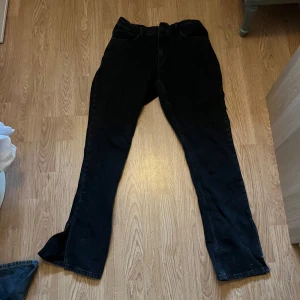 Lågmidjade bootcut  - Snygga svarta jeansbyxor med bootcut-stil. Perfekta för en stilren look. De har en klassisk design med fem fickor och knappgylf.