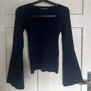 Mörkblå ribbad tröja - Säljer en stilren mörkblå ribbad tröja från shein. Tröjan har långa ärmar med en lätt utsvängd design och en rundad halsringning. Perfekt för en trendig look!