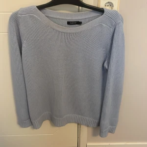 Ljusblå stickad tröja från b.young - Säljer en ljusblå stickad tröja från b.young. Tröjan har en rund halsringning och långa ärmar med ribbade muddar. Perfekt för en stilren och bekväm look.