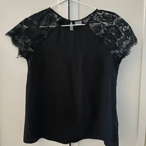 Svart blus med spetsdetaljer - Snygg svart blus med spetsdetaljer på ärmarna🌟🙏🏼aldrig använt!!