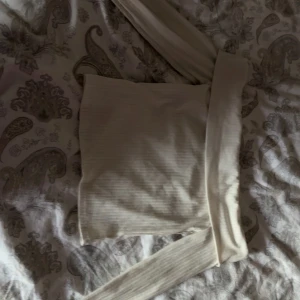vit offshoulder topp från H&M - säljer en stilren vit/krämvit offshoulder topp från h&m. toppen har långa ärmar och en ribbad struktur som ger en snygg passform. storlek s. hör av er vid intresse!💕pris går att diskuteras!