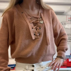 Beige stickad tröja med snörning - Säljer en snygg rosa stickad tröja med unik snörning framtill💕