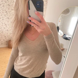 Beige kashmirtröja från Mango - Säljer en elegant beige kashmirtröja från Mango. Tröjan har en v-ringad design och långa. Den är mjuk och bekväm. Passar bra till både jeans och kjol💕💕