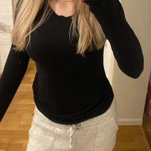 Svart långärmad tröja - Säljer en stilren svart långärmad tröja. Perfekt för en enkel och bekväm look. Passar bra till både jeans och mjukisbyxor.