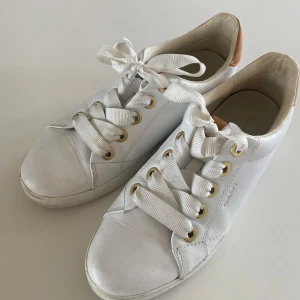 Sneakers GANT vita stl 39 - Snygga vita sneakers med bruna detaljer på hälen och vita snören. Jag upplever dem ngt små i stl, mer som 38. Normalt använda med en del märken på gummikanten som nog går att få bort. 