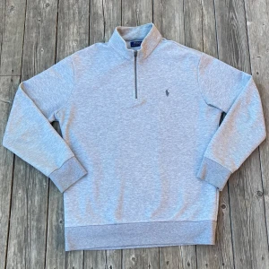 Grå tröja med dragkedja från Polo Ralph Lauren - Grå Polo Ralph Lauren tröja i mycket bra skick. Storlek XL men passar snarare L. Det finns inga defekter på tröjan. Hör av er om frågor!