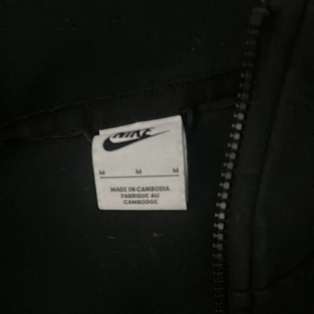 Säljer en stilren svart jacka från Nike med dragkedja och hög krage. Jackan har långa ärmar och en diskret logga på bröstet. Perfekt för en sportig look eller en avslappnad dag.. Takit.