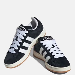 Svarta sneakers från Adidas - Snygga svarta Adidas Campus sneakers med vita detaljer och klassiska tre ränder. Skorna har en stilren design med vit sula och snörning. Perfekta för en avslappnad stil.knappt använda💕