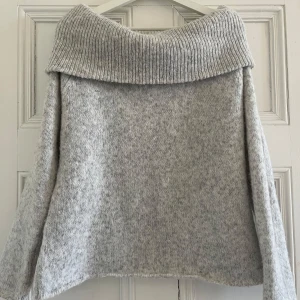 Grå stickad off shoulder tröja från Gina Tricot - Säljer denna mysiga grå stickade off shoulder tröjan från Gina! Köpt för nån månad sen och använd ca3 gånger. Väldigt fint skick fortfarande, nypris var 400!! 💕🪷 Perfekt för en lite kylig sommarkväll osv