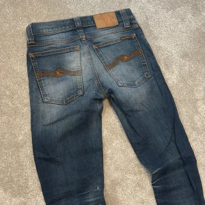 Nudie jeans - Nudie jeans blå schysst tvätt, slimfit modell. Storlekslappen är bortklippt men de är små i midjan tror typ 27 eller nått sånt och typ 30 i längden. Inga bud.