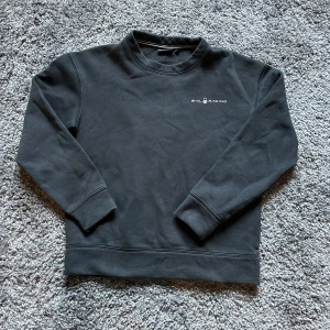 Svart sweatshirt från Sail Racing - Svart sweatshirt från Sail Racing med diskret logga på bröstet och en liten logga i nacken. Tröjan har rund hals, långa ärmar och ribbade muddar. Perfekt basic att ha i garderoben och lätt att matcha med allt.