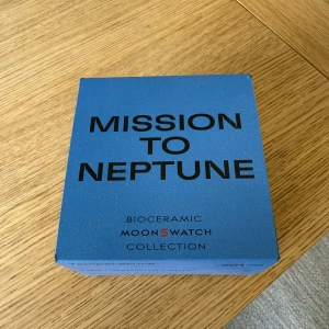 Omega x Swatch MoonSwatch Neptune - Säljer en Omega x Swatch MoonSwatch Mission to Neptune. Klockan har en blå boett i biokeramik, svart urtavla med vita detaljer och svart textilband med Omega-logga. Sportig och futuristisk design, perfekt för dig som gillar unika accessoarer. Klockan är inte använd och är köpt i Florence. Skriv ifall ni har frågor eller funderingar 
