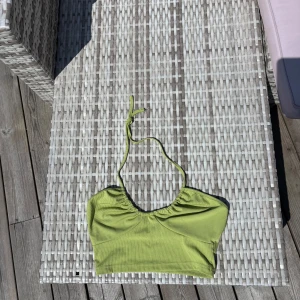 Ljusgrön halterneck från SHEIN - Snygg ljusgrön topp från SHEIN i ribbat material. Toppen har en halterneck med knyt och lätt rynkade detaljer framtill. Perfekt för strandhäng och poolparty i sommar!