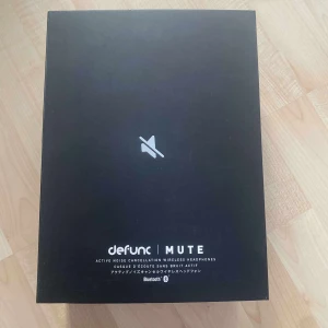 Helt ny hörlurar! - Bilderna visar en förpackning med trådlösa hörlurar från Defunc, modell MUTE, med aktiv brusreducering. Det är ingen bok på bilderna, utan elektronik (hörlurar).