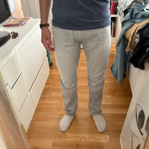 Ljusgrå jeans från Mango Man - Säljer ett par ljusgrå jeans från Mango Man med klassisk femficksdesign och raka ben. Jeansen har straight passform. Perfekta för en clean och stilren look nu i sommar. 