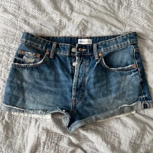 Jeansshorts från Zara - Säljer dessa snygga denim shorts från Zara med  slitningar och knapp-gylf❤️Shortsen är inte använda och är i superbra skick. Kom gärna med prisförslag