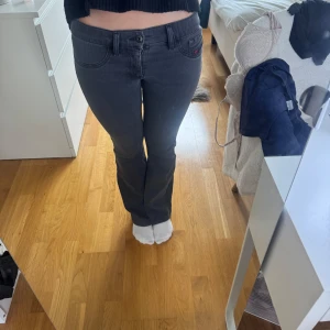 Mörkgrå bootcut jeans - Snygga mörkgrå jeans med bootcut passform och klassiska fem fickor. Jeansen har normal midja och är tillverkade i stretchigt bomullsmaterial för en bekväm känsla. Perfekta för dig som gillar en tidlös look med lite utsvängda ben.
