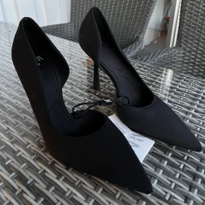 Svarta pumps med spetsig tå från Zara - Stilrena svarta klackar från Zara i storlek 38. Köpte utomlands (26€, se bild) men har aldrig använt. 