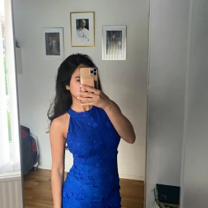 Blå halterneck festklänning med broderi - Blå festklänning som passar till alla typer av fester med en väldigt fin form och broderi