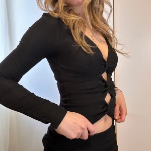Svart ribbad croppad långärmad topp - Snygg svart ”figursydd” topp. Perfekt för fest eller till lite kyligare sommarnätter. Stretchigt tyg. Helt oanvänd då jag spontant köpte den😅🌸