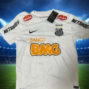 Vit Santos Neymar Jr fotbollströja Nike - Santos FC matchtröja i vitt med Neymar Jr och nummer 11 på ryggen. Tröjan har korta ärmar, flera sponsorloggor och klubbmärke på bröstet. Tillverkad i lätt och ventilerande material, perfekt för fotbollsälskare som vill sticka ut på planen. Storekar S,M