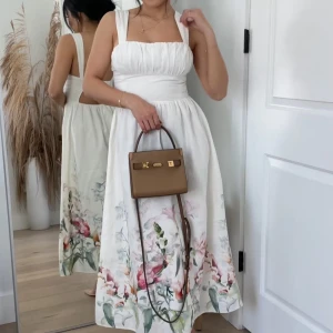 Hm Linneblandning långklänning med blommor - Så vacker klänning ifrån Hm. Vit klänning med blommor.Längst ner. Rynkade detaljer vid bysten. Sitter tight i midjan och sen släpper den när kjolen kommer. Perfekta midsommar klänningen. storlek XS helt ny med lapp. yttertyg:55%Linne 45%bomull innertyg 100% bomull