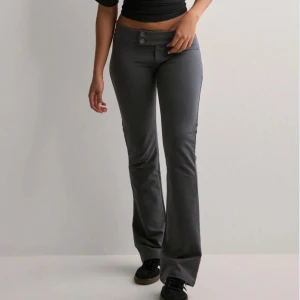 Mörkgrå bootcut byxor - Snygga mörkgrå bootcut byxor. Byxorna har låg midja och är tillverkade i ett stretchigt, mjukt material som sitter skönt på kroppen. Aldrig använda!