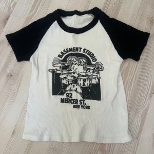 T-shirt med tryck  - Snygg t-shirt med svartvita kontraster och coolt Basement Studio-tryck. Använd 1-2 gånger, inga defekter.