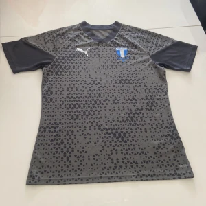 Malmö FF grå matchtröja Puma M - Snygg grå Malmö FF fotbollströja från Puma med svart triangulärt mönster på framsidan. 